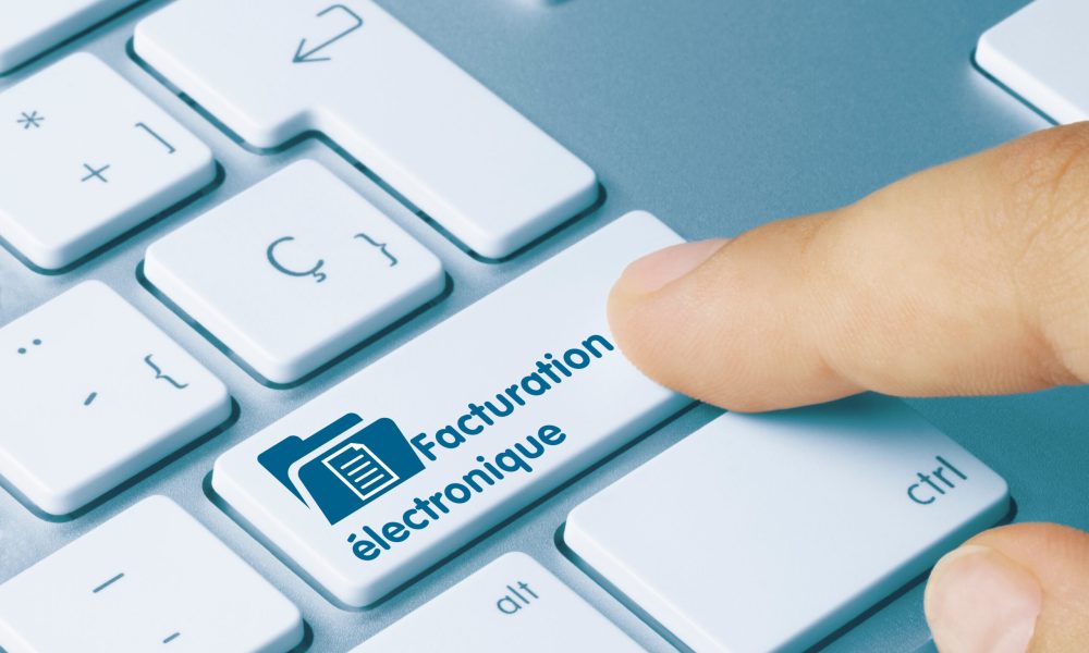 Facturation électroniqueÉ crit sur la touche bleue du clavier métallique. Touche en appuyant sur le doigt.