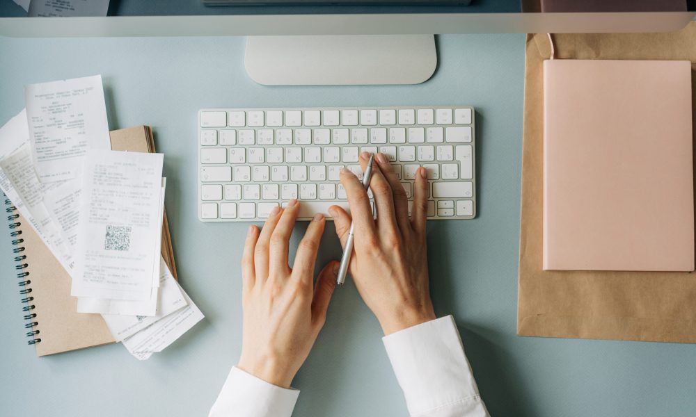 Top view of female hands typing on a computer keyboard. Business woman in the office.